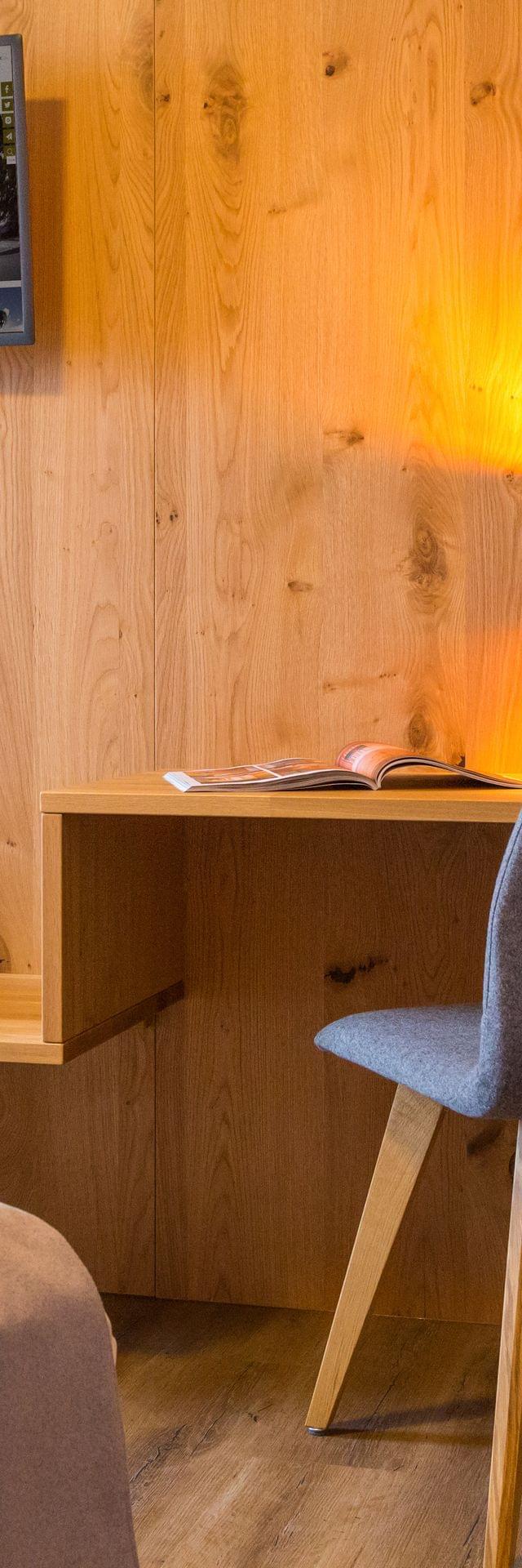 Schlafzimmer mit Sitzmöglichkeit und TV an Wand 