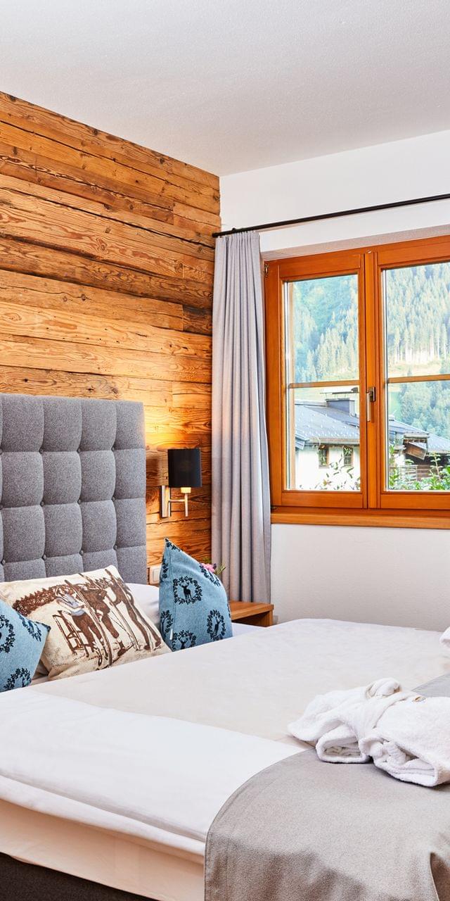 Gemütliches Hotelzimmer mit Holzverkleidung, Bergblick und modernem Design