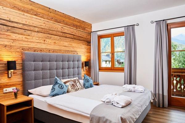 Gemütliches Hotelzimmer mit Holzverkleidung, Bergblick und modernem Design