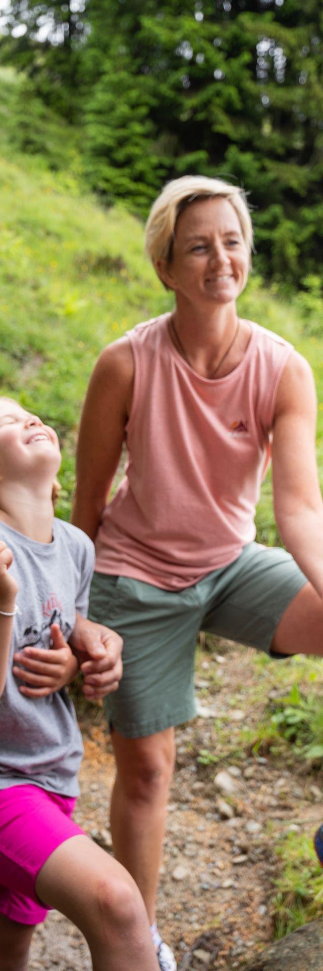 Happy family hiking in the mountains with children posing next to a fox statue