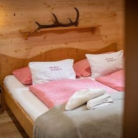 Cozy alpine bedroom with red checkered bedding and wooden interior walls