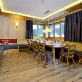 Cozy alpine dining room with wooden furniture, set table and mountain view