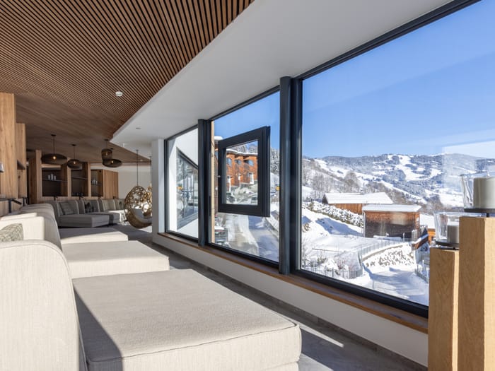 The bathhouse relaxation room with large loungers and a panoramic window overlooking the winter landscape.
