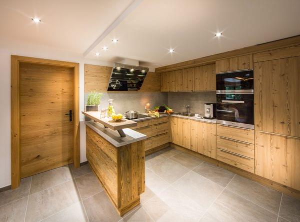 Moderne Holzküche mit Einbaugeräten, Kücheninsel und frischem Gemüse auf der Arbeitsplatte