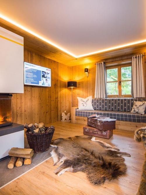 Gemütliches Wohnzimmer im Alpenstil mit Kamin, Holzverkleidung und rustikaler Einrichtung