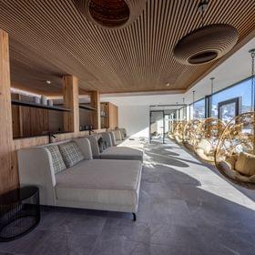 The bathhouse relaxation room with large loungers and a panoramic window overlooking the winter landscape.