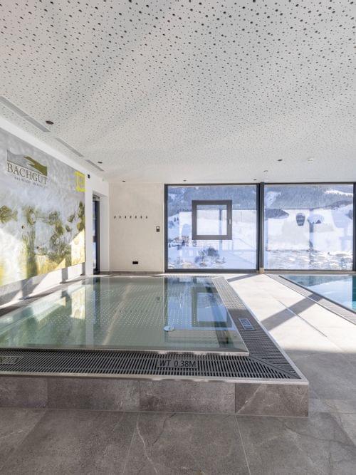 Badehaus Kinderbereich, Kinder-Wasserbecken mit Fischen an der Wand und Ausblick auf die Verschneite Bergwelt 