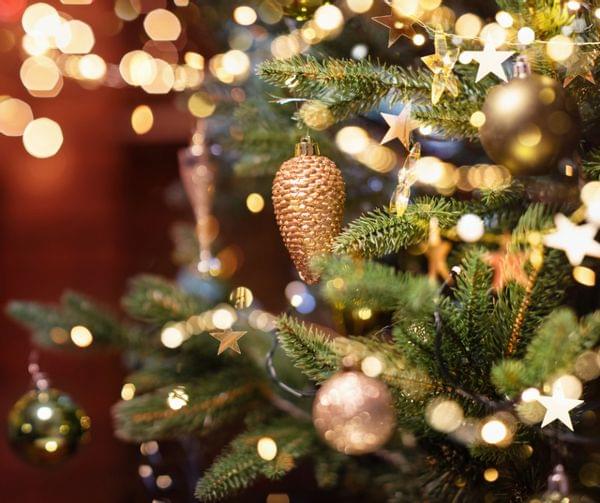 Weihnachtsbaum mit goldenen Kugeln, Tannenzapfen und Lichterkette geschmückt