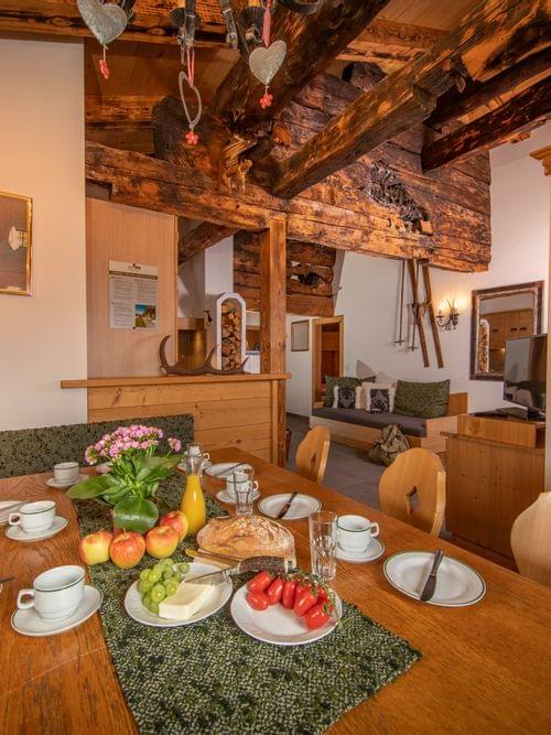 Gemütliches Alpen-Esszimmer mit Holzbalken, gedecktem Frühstückstisch und rustikaler Deko