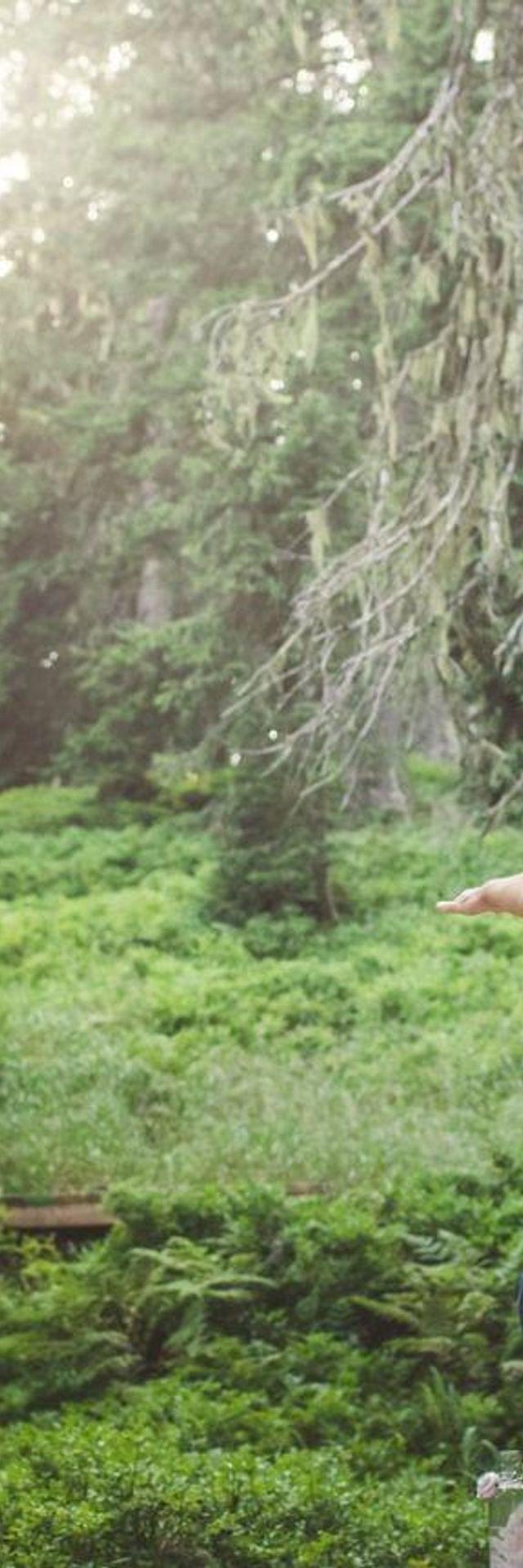 2 Frauen die auf einer Yogaplattform im Wald Yoga machen 