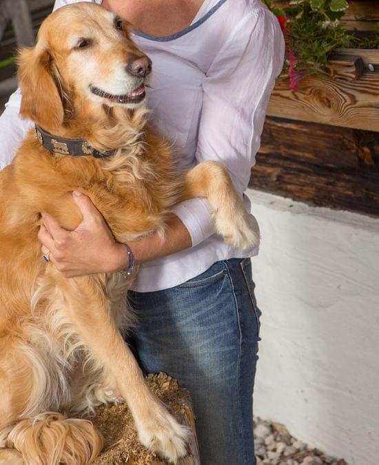 Frau mit Hund vor der Almhütte 