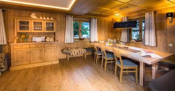 Gemütliches alpenländisches Esszimmer mit Holzmöbeln, Bank und warmer Beleuchtung