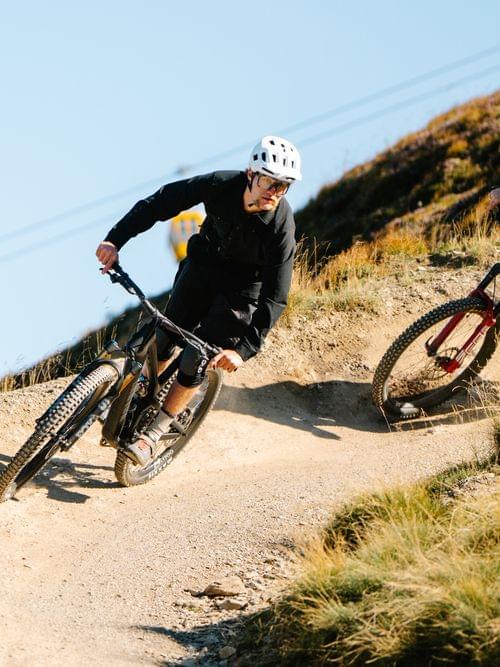 2 Downhiller fahren einen Trail hinab