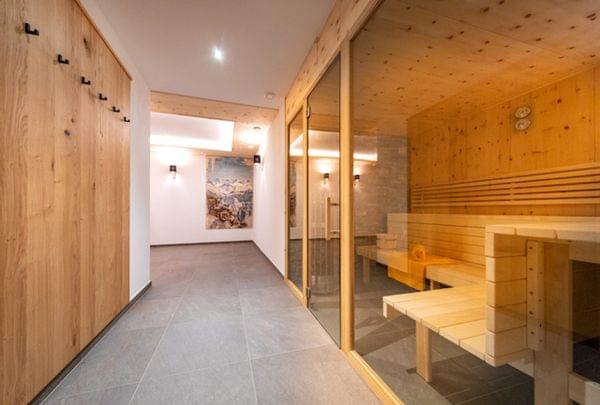 Moderner Wellnessbereich mit Holzsauna, gefliestem Boden und Wandkunst