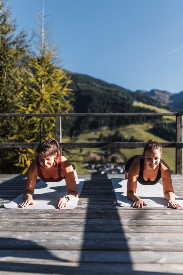 Two women doing yoga outdoors.
