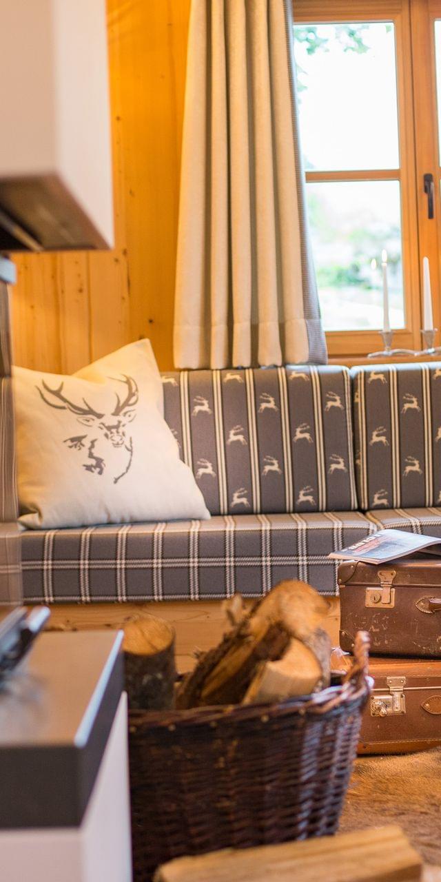 Cozy alpine living room with fireplace, wood accents, plaid sofa and vintage suitcases