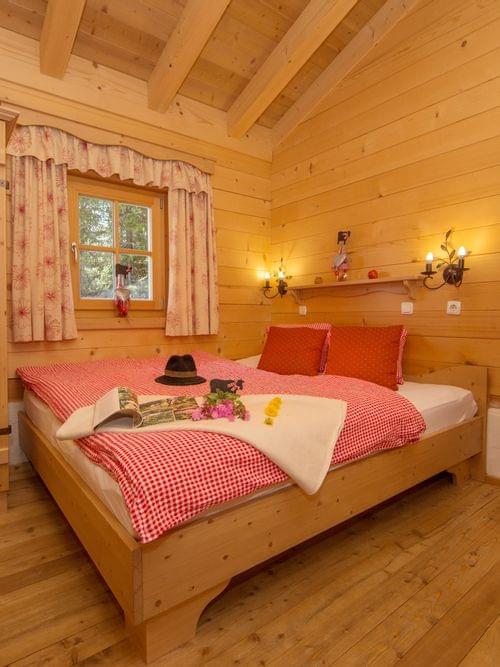 Cozy alpine bedroom with wooden furniture, red checkered bedding, and rustic decor