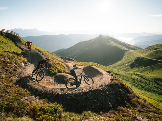 3 Mountainbiker die einen Trail den Berg herunter Fahren 