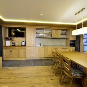 Moderne Alpinküche mit Holzmöbeln, langem Esstisch und Einbaugeräten