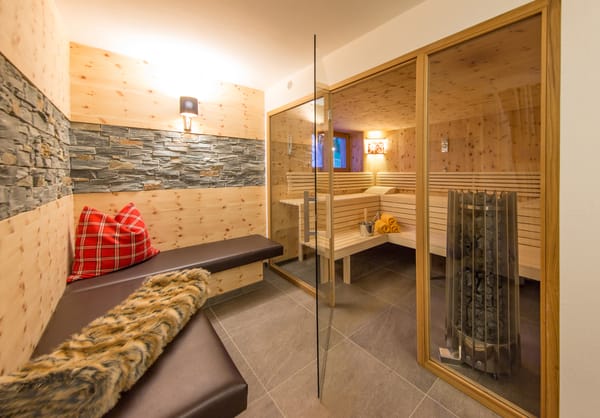 Große Sauna mit Glasfront, davor eine Gemütliche Bank zum ausruhen 