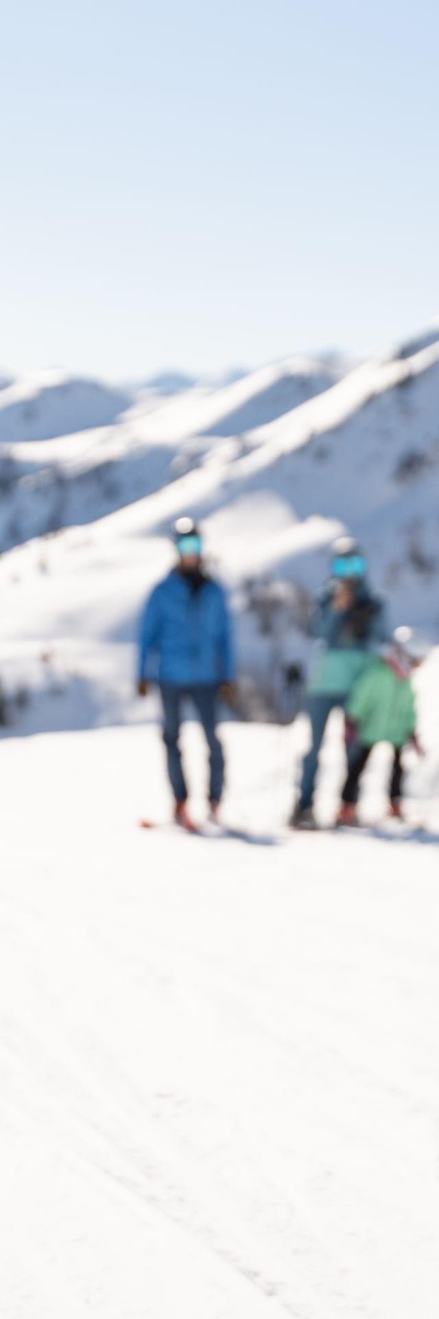 Kind mit seinen Eltern im Schnee, das Kind hat einen Schneeball in der Hand 