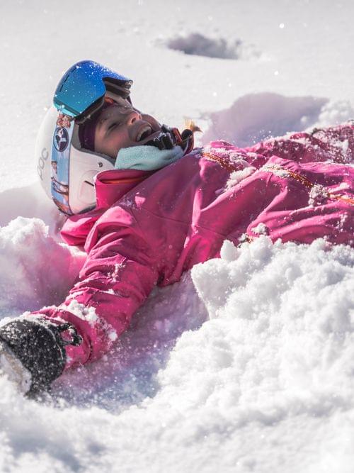 Kind liegt im Schnee 