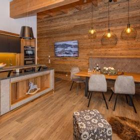 Moderne rustikale Küche und Essecke mit Holzmöbeln und gemütlicher Beleuchtung