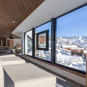 Badehaus Ruheraum mit Großen Liegen und Panoramafenster mit Ausblick auf die Winterlandschaft 