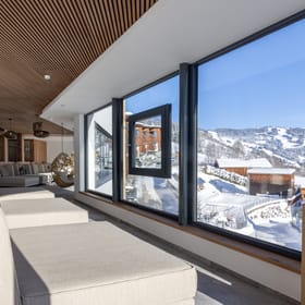 The bathhouse relaxation room with large loungers and a panoramic window overlooking the winter landscape.