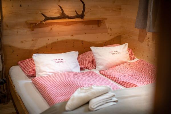 Cozy alpine hotel room with red checkered bedding and wooden interior walls