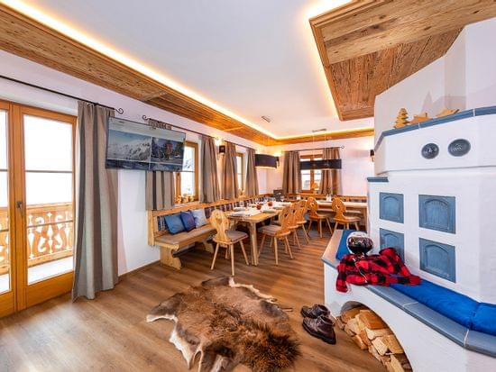 Cozy alpine chalet dining room with wooden furniture, fireplace and rustic decor