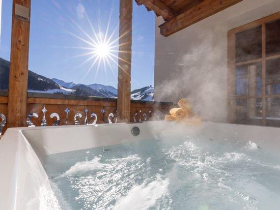 Sprudelnde Whirlwanne mit Ausblick auf die Verschneite Bergwelt 