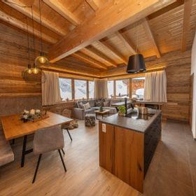 Moderne Alpenchalet-Küche und Essbereich mit Holzausstattung und Bergblick