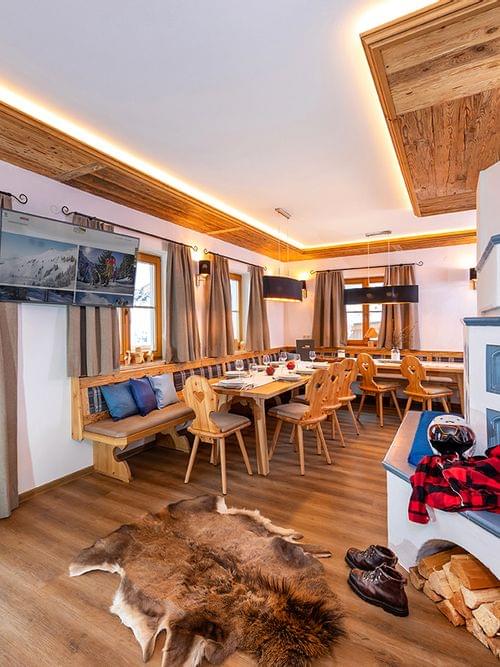 Cozy alpine chalet dining room with wooden furniture, fireplace and rustic decor