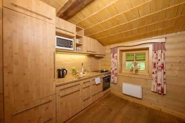 Gemütliche Holzküche mit modernen Geräten und rustikaler Hüttendekoration