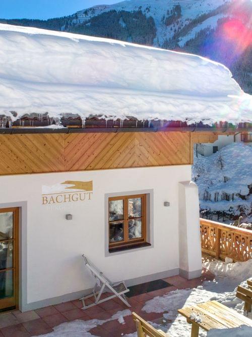 Gemütliches Alpenchalet Bachgut in verschneiter Berglandschaft bei strahlender Wintersonne
