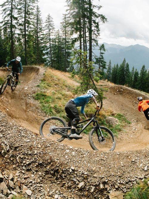 3 Mountainbiker auf einem Biketrail 
