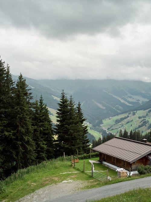 Alpenhütte aus Holz von Tannen umgeben mit Blick ins Bergtal