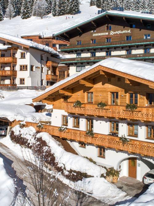 Charming alpine chalet buildings in snowy mountain village under blue sky