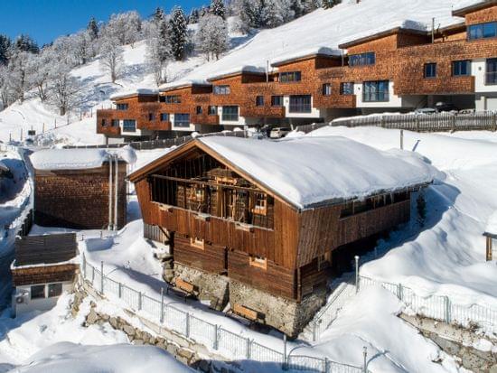 Snow-covered Alpine chalets and modern lodges on a sunny winter mountain slope