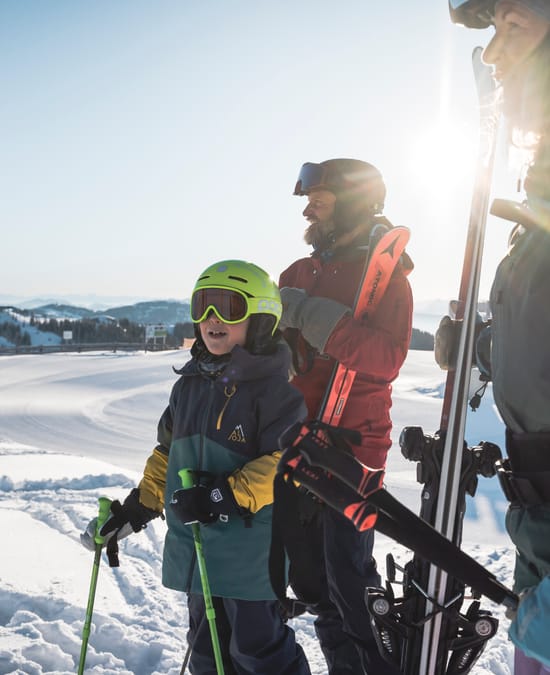 A family with a child skiing on the mountain.