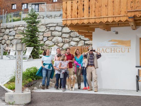 Familiengruppe mit Hund vor dem Bachgut Bergresort im Sommer