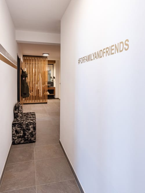 A hallway with a dressing area, featuring the words “For Family and Friends” on the wall.