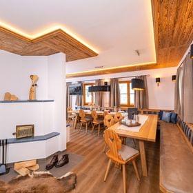 Gemütliches alpines Esszimmer mit Holzmöbeln, Kamin und stimmungsvoller Beleuchtung