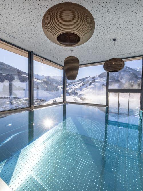 The Bachgut bathhouse indoor pool with a view of the winter landscape.