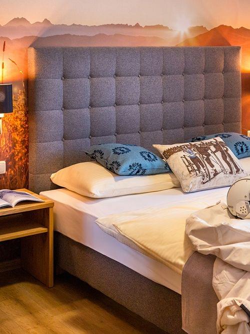 Cozy hotel room with mountain-themed decor, helmet and ski gear on bed