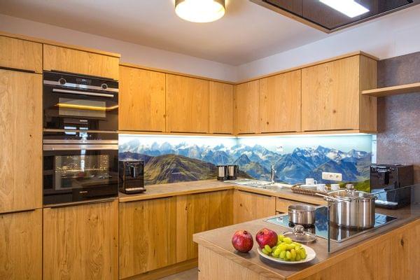 Moderne Holzküche mit Einbaugeräten und Rückwand mit Berglandschaft