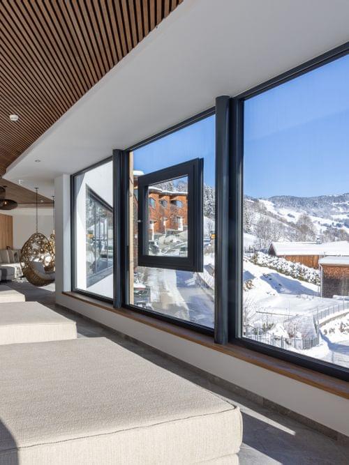 The bathhouse relaxation room with large loungers and a panoramic window overlooking the winter landscape.
