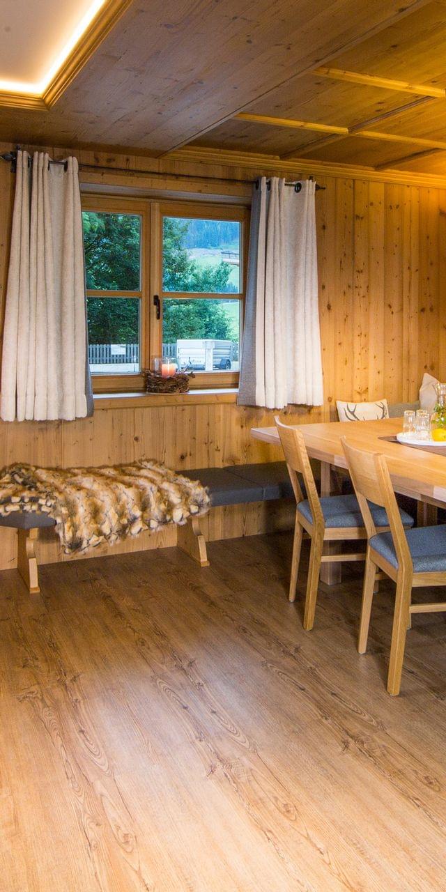 Gemütliches alpenländisches Esszimmer mit Holzmöbeln, Bank und warmer Beleuchtung