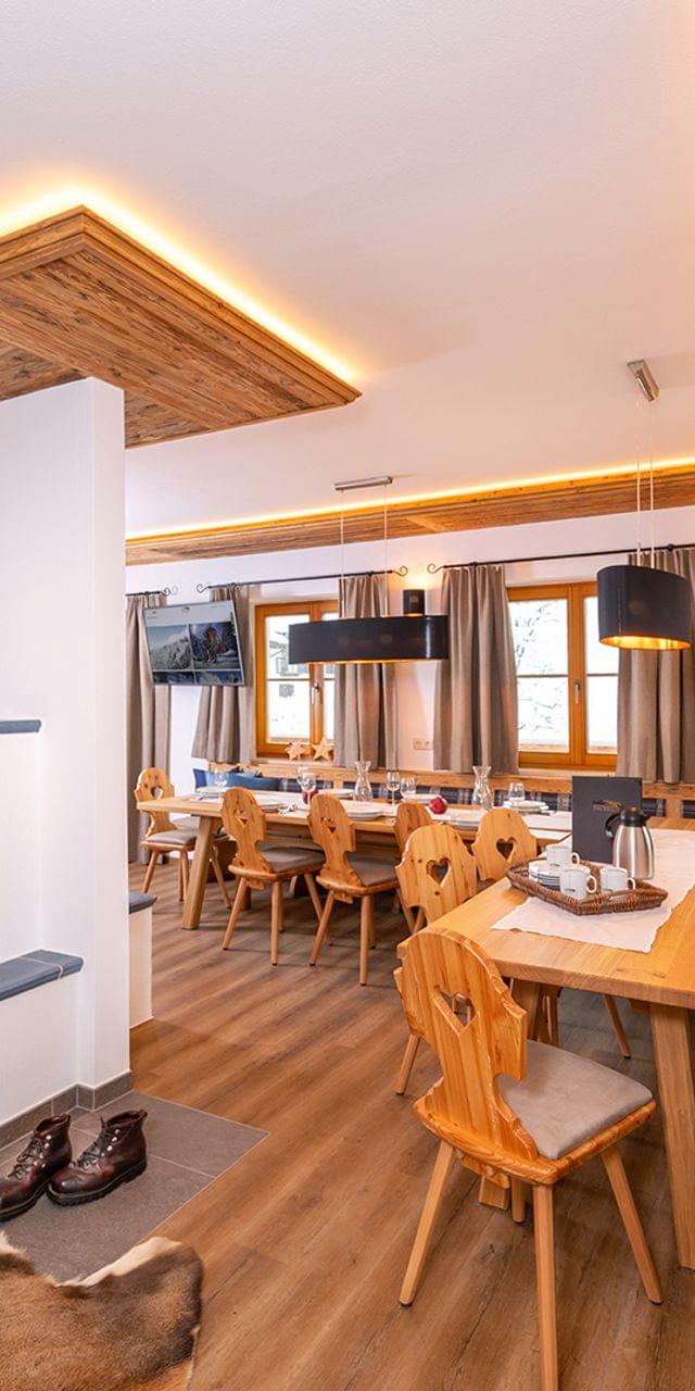 Gemütliches alpines Esszimmer mit Holzmöbeln, Kamin und stimmungsvoller Beleuchtung